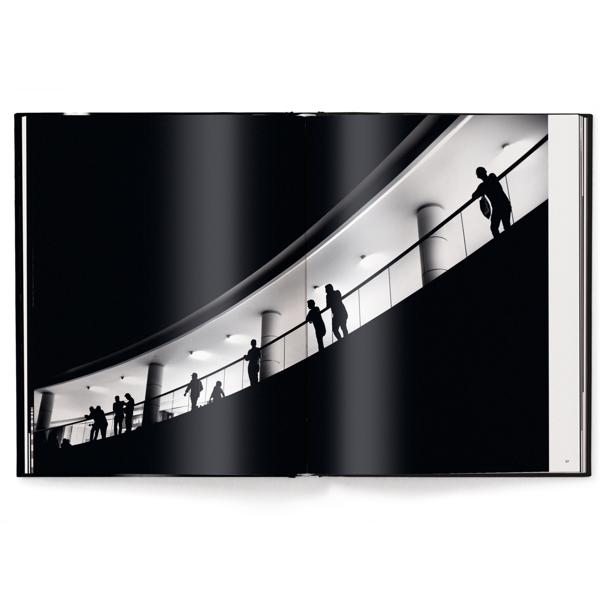 Silhouettes of people on a modern architectural staircase with white lighting.