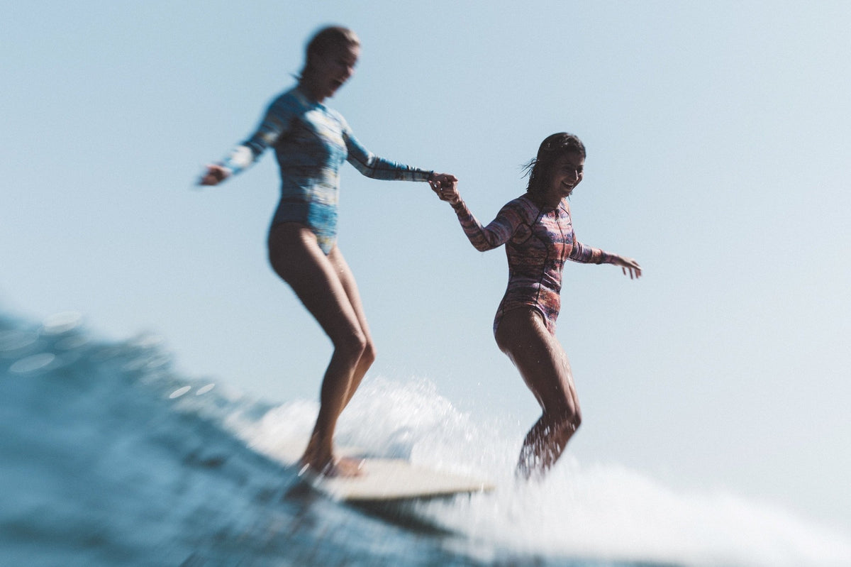 Two female surfers on a wave in She Surf