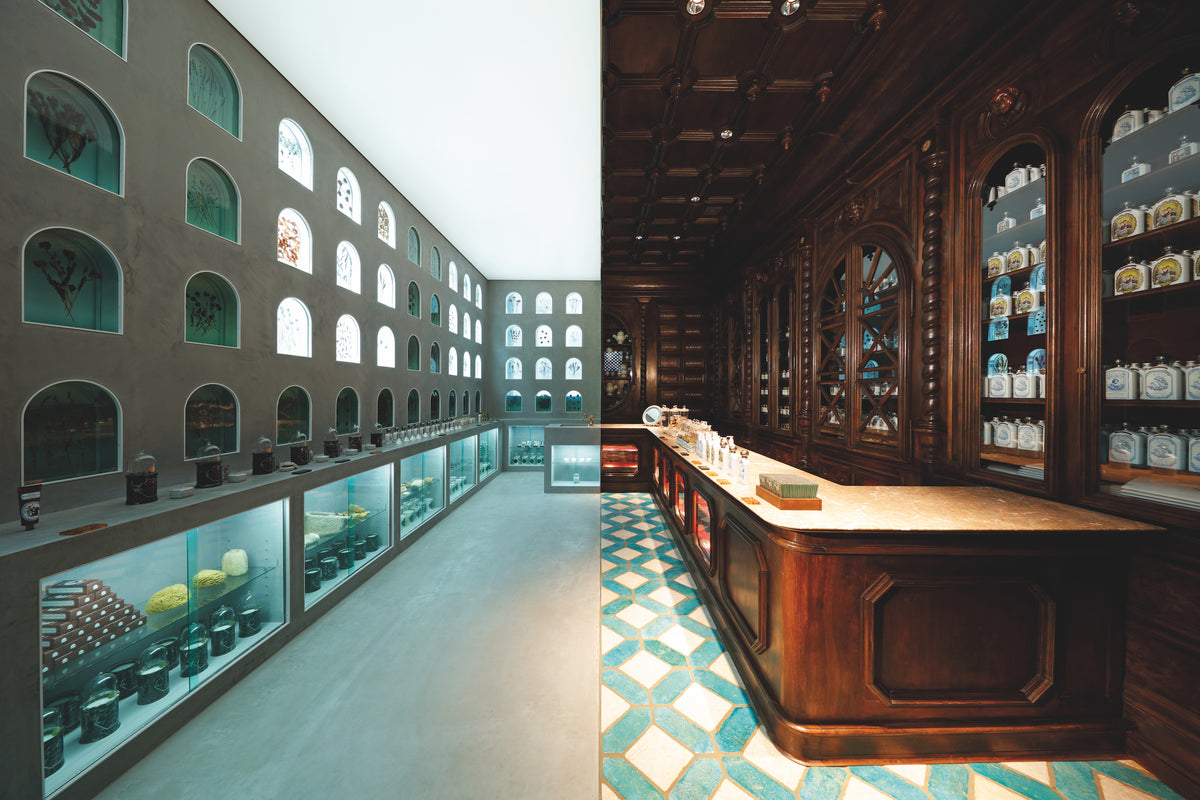 Officine Universelle Buly’s shop in Tokyo represents an architectural extravagance—a space that embodies the bridges built by Buly be- tween eras and cultures. This audacity was rewarded with two prizes at the 2018 Frame Awards. One half of this bisected store is straight out of 19th-century France: marvellously refined wooden or- naments—pillars with helicoidal engaged columns, candelabras with their bobeches, dentil frieze, cornice, and coffered ceiling—are on display, like a Haussmanian facade.