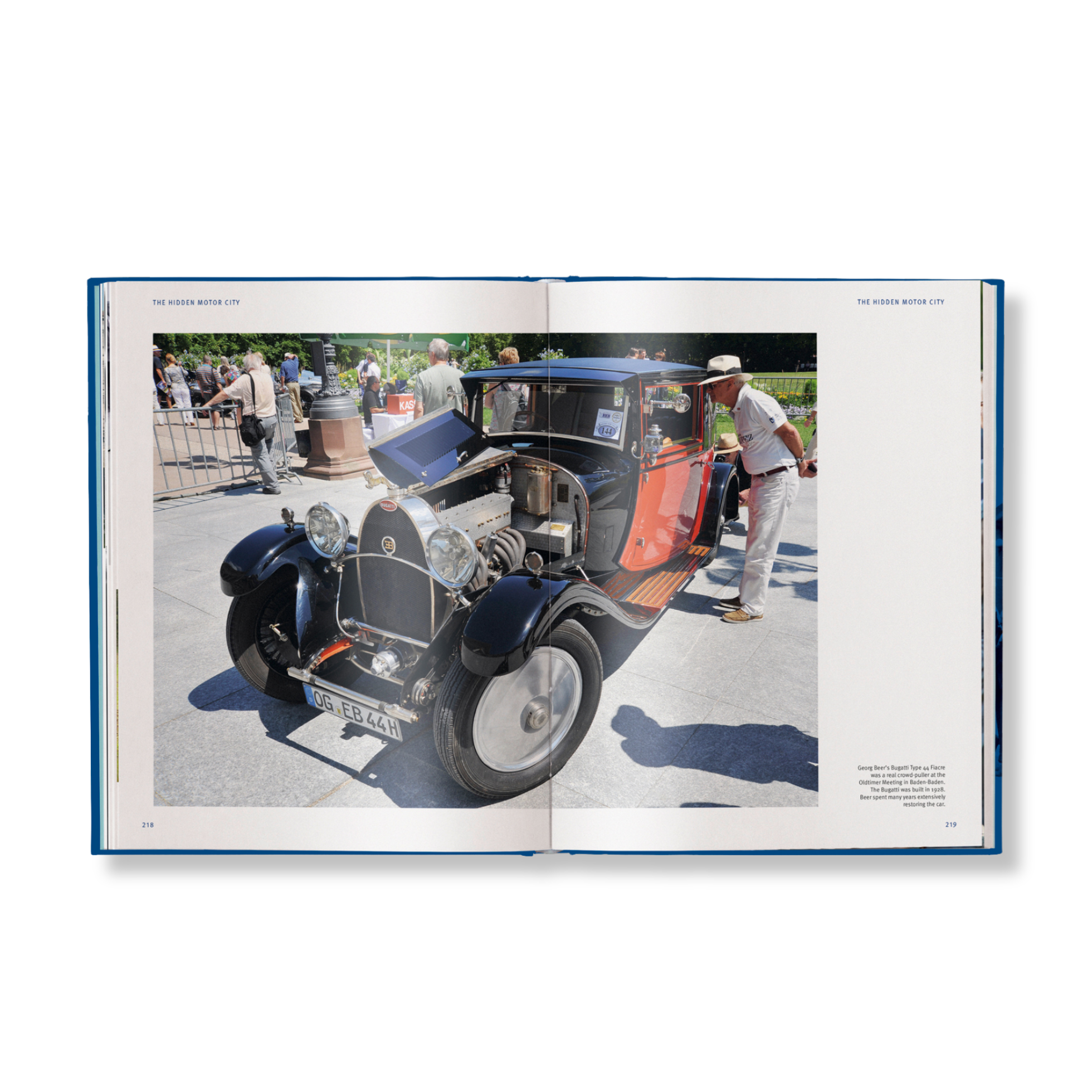 Open book showing a vintage car at an outdoor event with people around.
