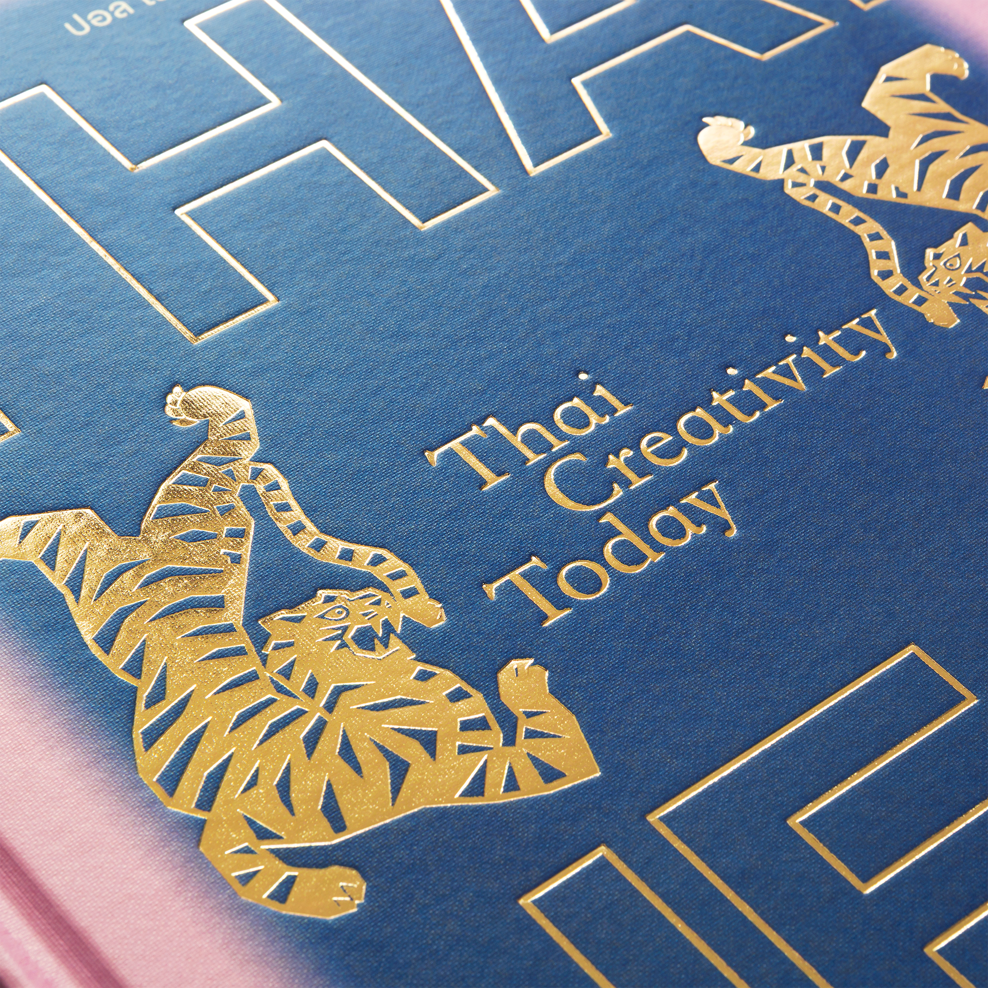 Blue book cover with gold tigers and text 'Thai Creativity Today'
