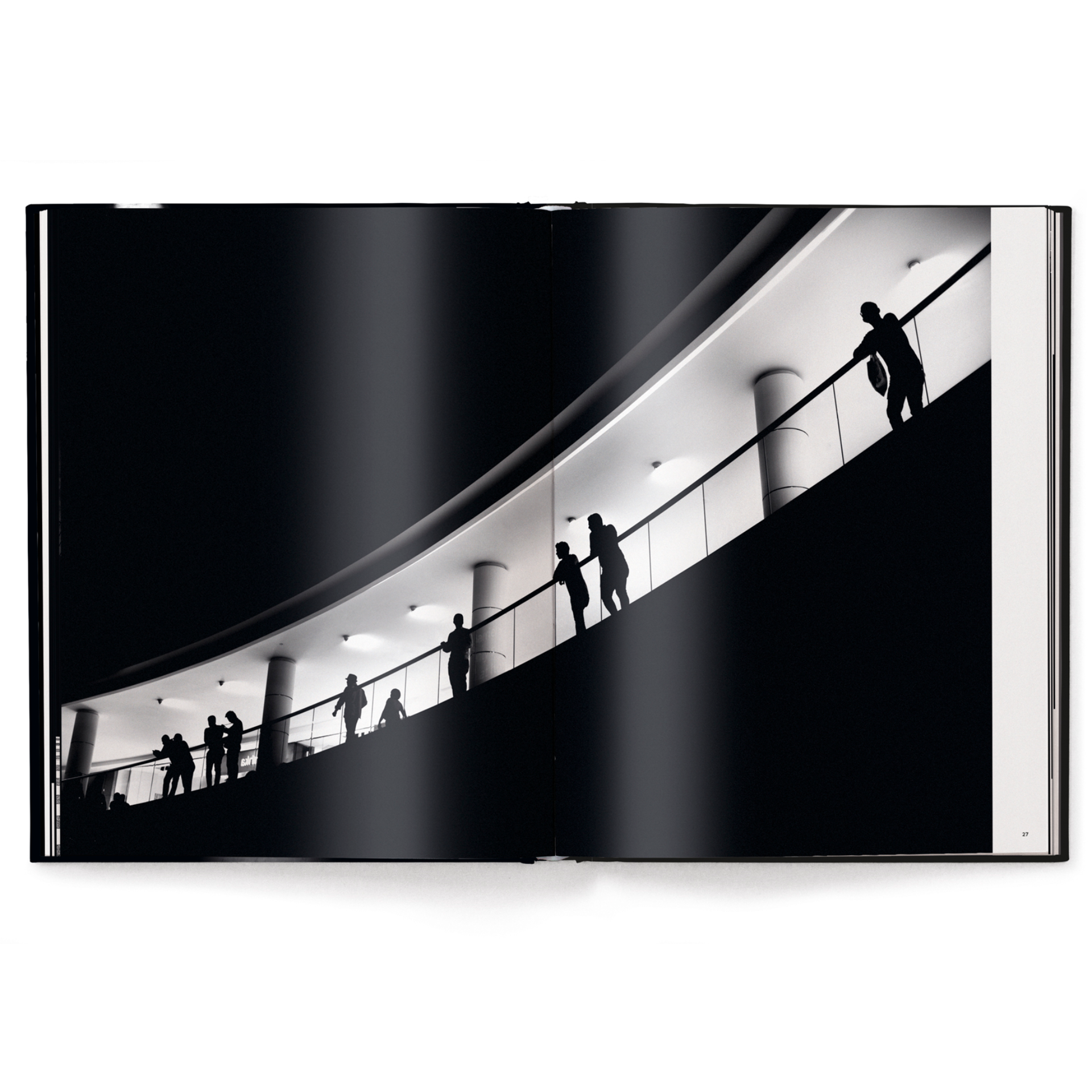 Silhouettes of people on a modern architectural staircase with white lighting.