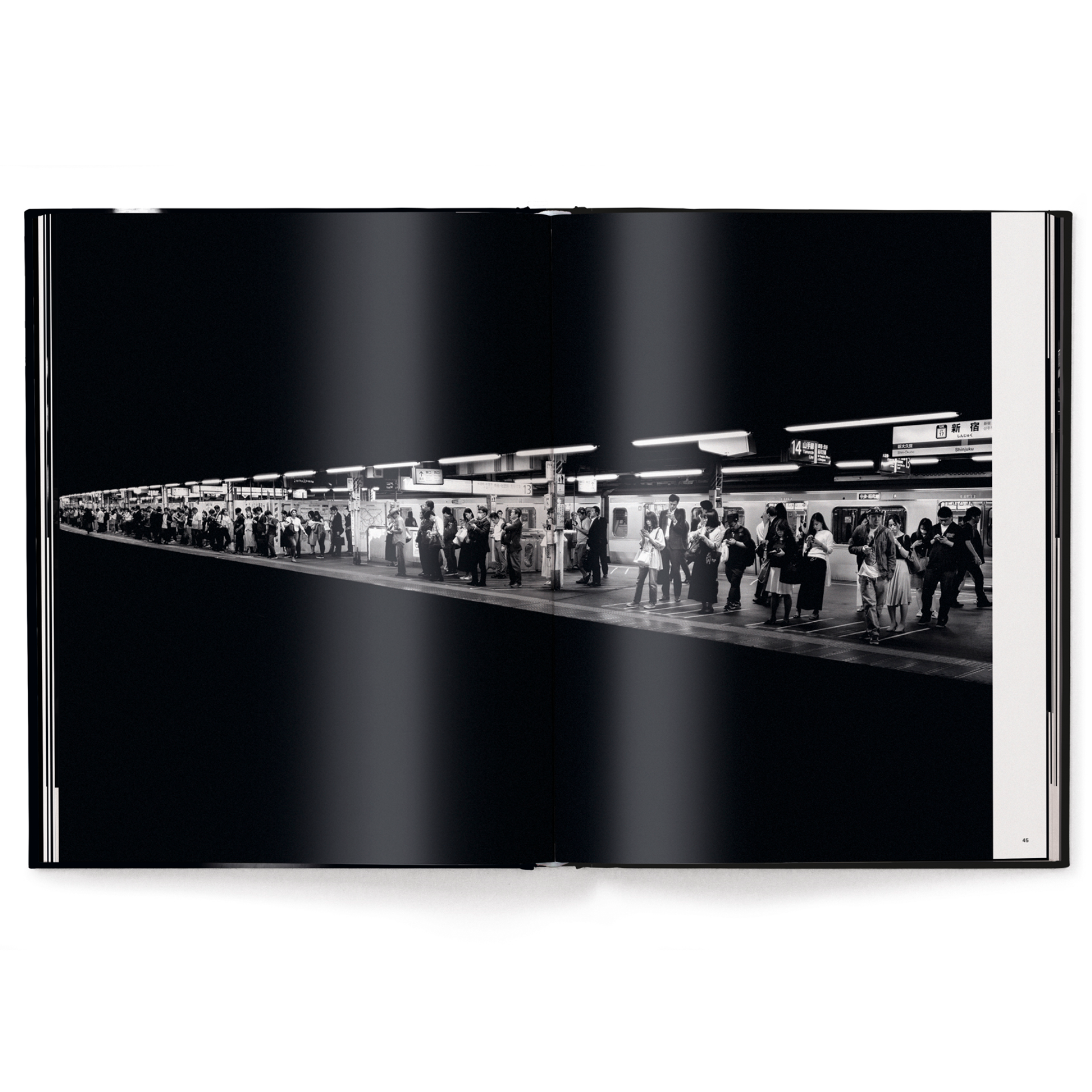 Open book showing a black and white photograph of a train station platform with people waiting.
