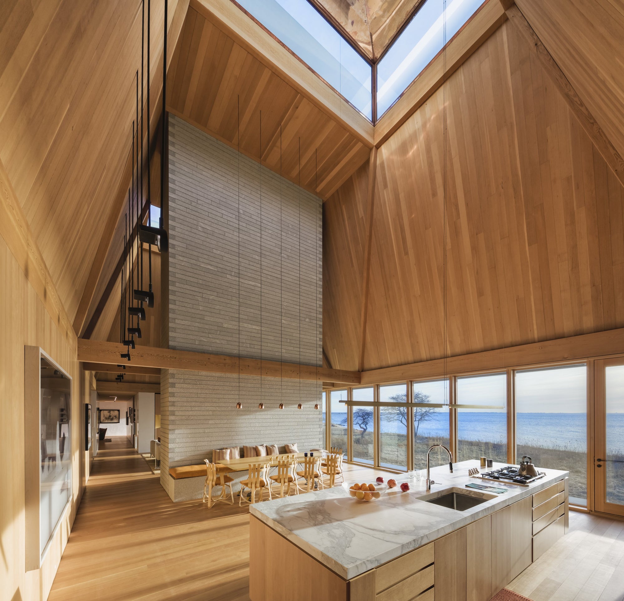 The rich tone of wood of this incredible house is continued in the chairs, table, flooring, and cabinetry, with complementary seating upholstered in creamy hues. Find out more in Out of the Woods by gestalten.