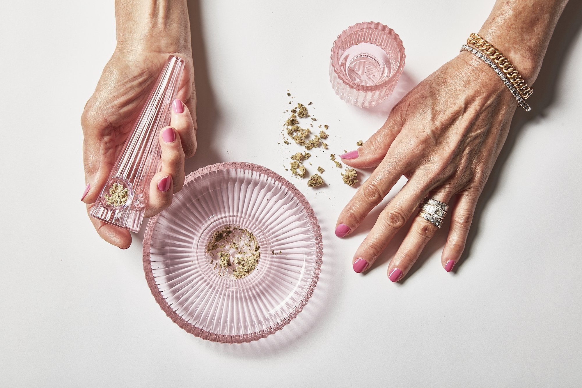 Fashioned from rose-pink ridged glass, this elegant three-piece set of marijuana accessories features an ashtray, grinder, and pipe in High on Design